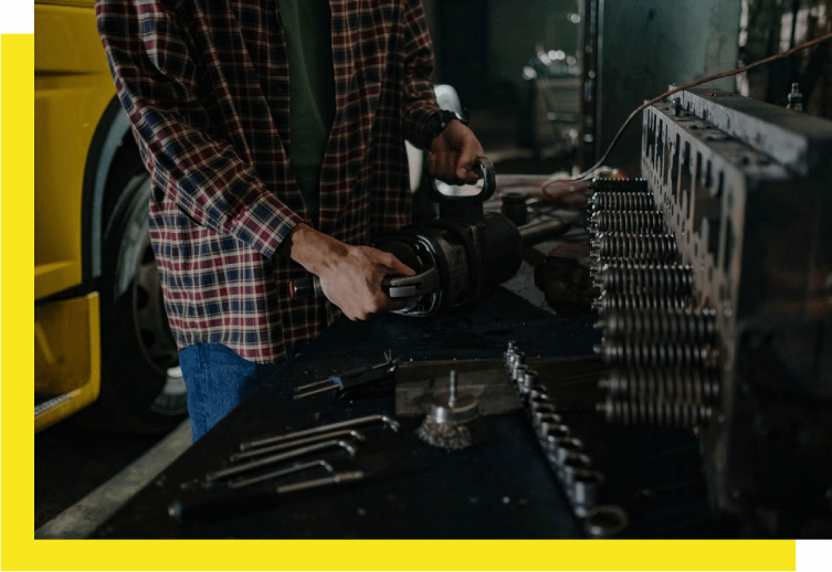 A man working in a garage with many tools.