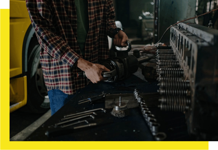 A man working in an industrial setting with many tools.