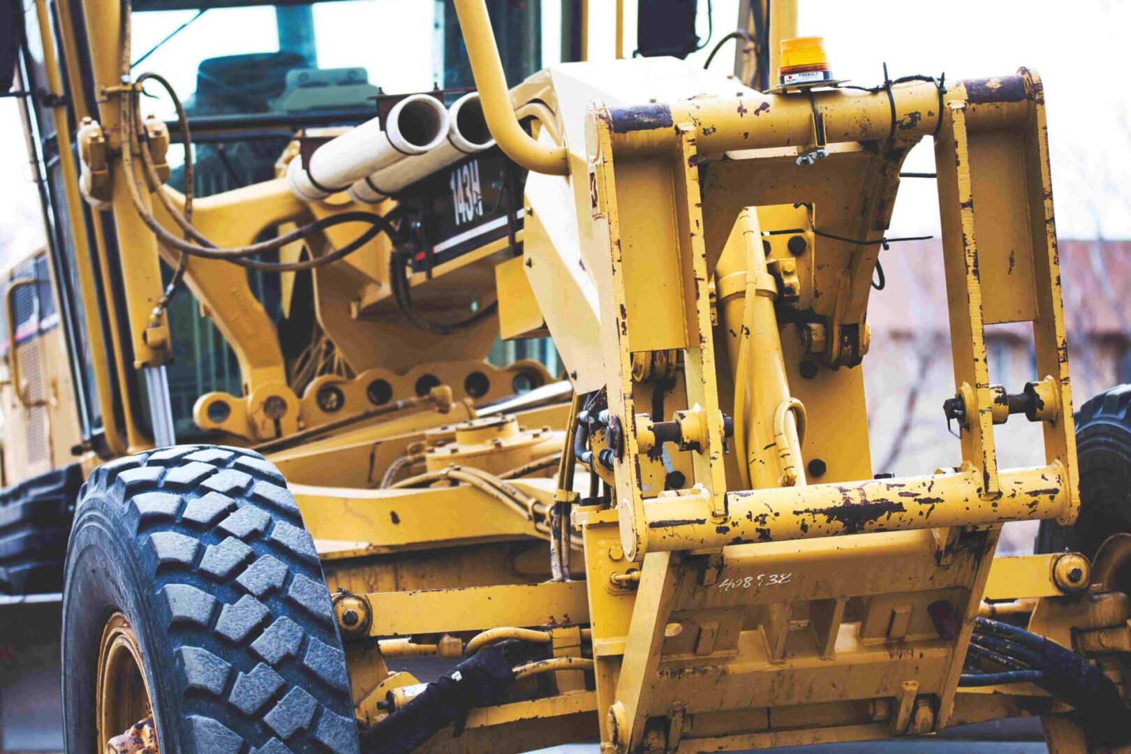 A yellow tractor with large tires is parked.